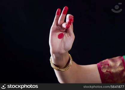 Close-up of a woman&rsquo;s hand making Bharatanatyam gesture on black background