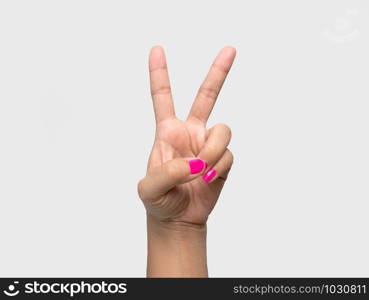 Close-up of a woman&rsquo;s hand showing V sign with a pink nail polish isolated on a white background.