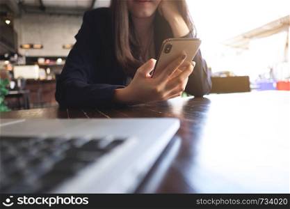 Close up of a woman using mobile smart phone on the table.