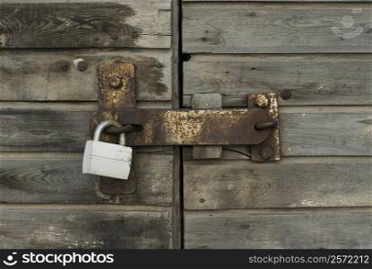 Close-up of a wooden door with a padlock
