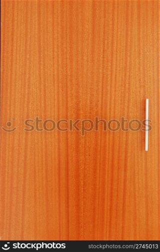 close up of a wooden wardrobe door with a metal handle