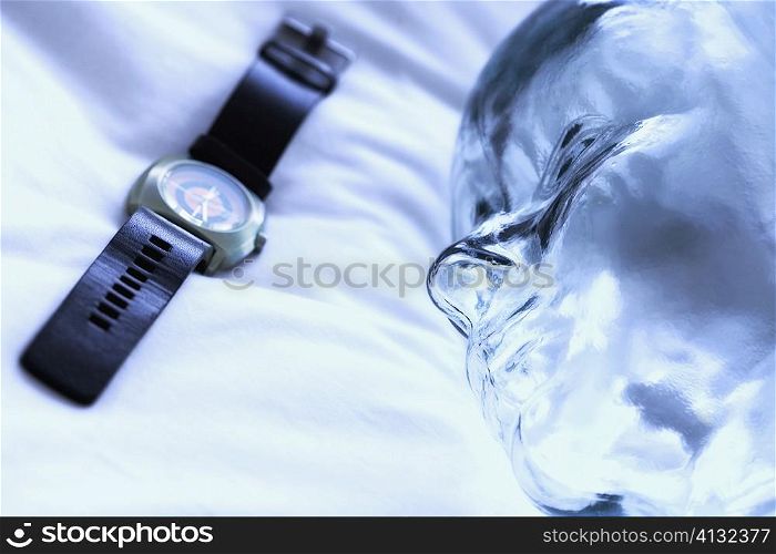Close-up of a wristwatch with a glass statue