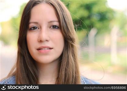 Close up of a young beautiful woman outdoors.. Close up of a young woman outdoors.