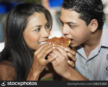 Close-up of a young couple eating a burger