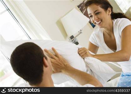 Close-up of a young couple having a pillow fight