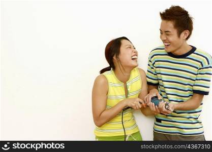 Close-up of a young couple holding a drill and laughing