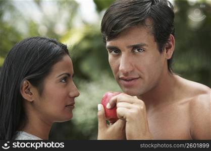 Close-up of a young couple holding an apple