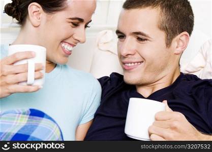 Close-up of a young couple holding coffee cups