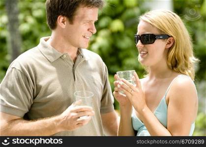 Close-up of a young couple holding glasses and smiling