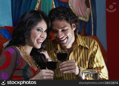 Close-up of a young couple holding glasses of red wine