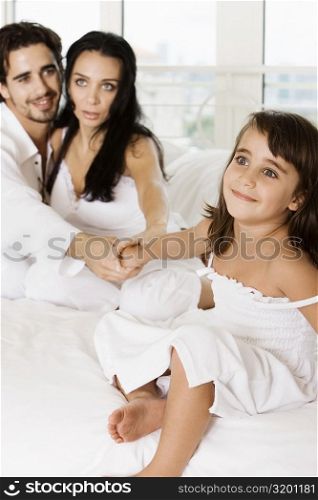 Close-up of a young couple holding their daughter&acute;s hands