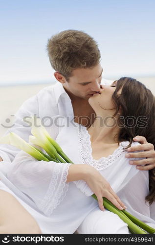 Close-up of a young couple kissing each other on the beach