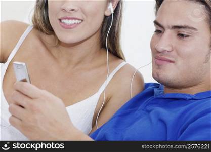 Close-up of a young couple listening to an MP3 player