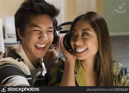 Close-up of a young couple listening to music and smiling