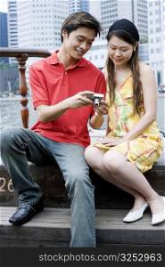 Close-up of a young couple looking at a digital camera