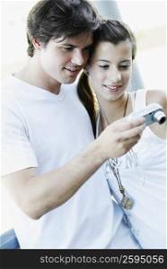 Close-up of a young couple looking at a digital camera and smiling
