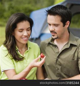 Close-up of a young couple looking at a strawberry