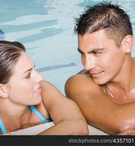 Close-up of a young couple looking at each other at the poolside