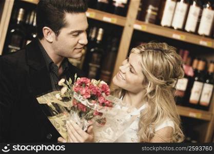 Close-up of a young couple looking at each other in a liquor store
