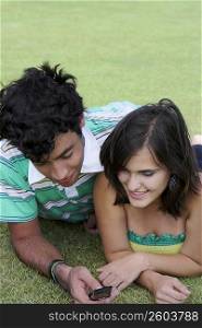Close-up of a young couple lying in a lawn and smiling