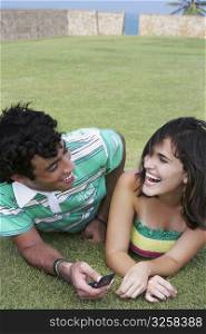 Close-up of a young couple lying in a lawn and smiling