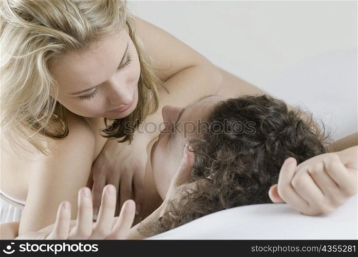 Close-up of a young couple lying on the bed and romancing