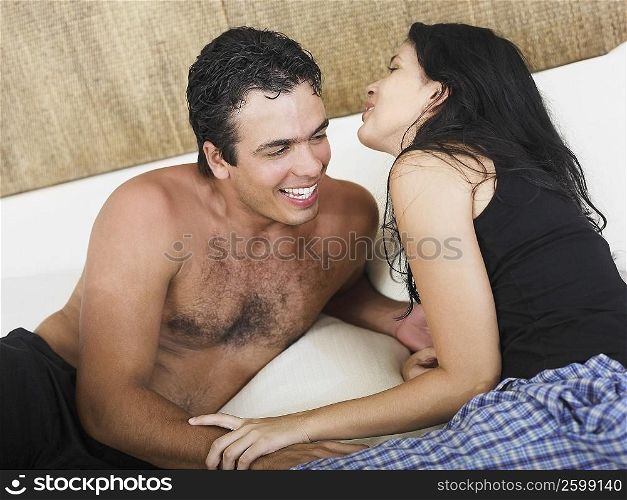 Close-up of a young couple reclining on the bed and smiling