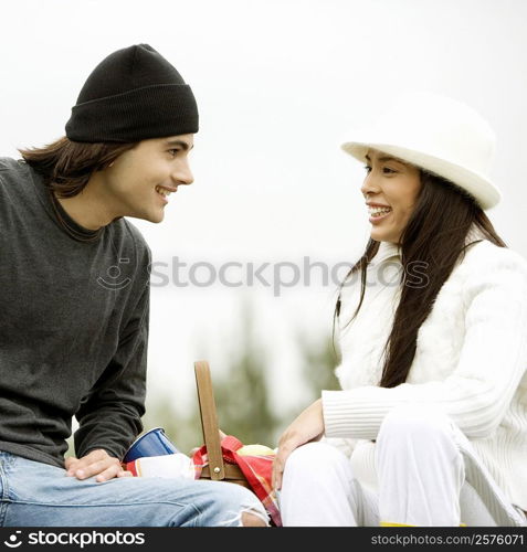 Close-up of a young couple sitting and smiling