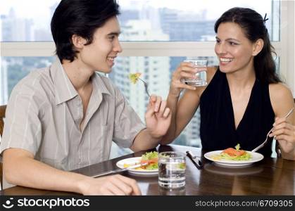 Close-up of a young couple sitting at a dining table
