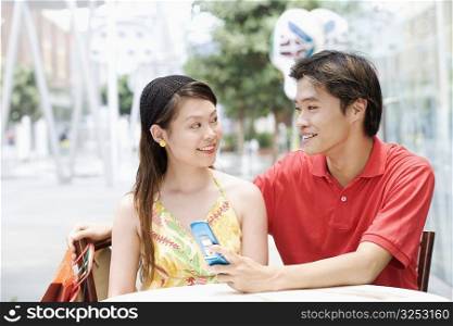 Close-up of a young couple sitting in a cafeteria and smiling