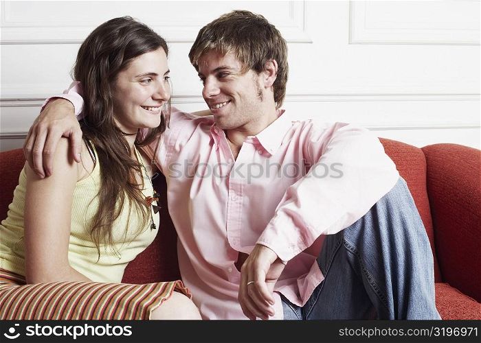 Close-up of a young couple sitting on a couch and looking at each other