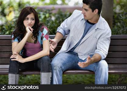 Close-up of a young couple sitting on a park bench