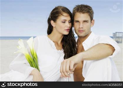 Close-up of a young couple sitting on the beach