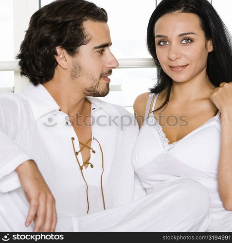 Close-up of a young couple sitting together on the bed