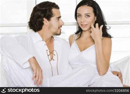 Close-up of a young couple sitting together on the bed