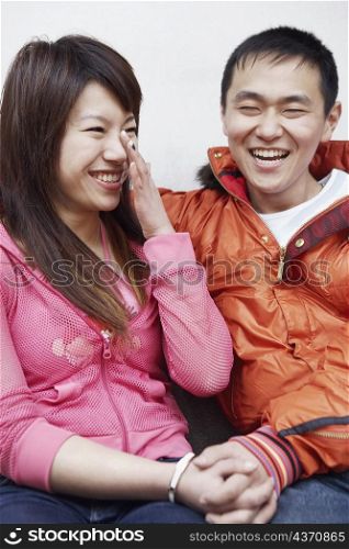 Close-up of a young couple sitting together smiling