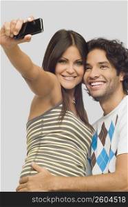 Close-up of a young couple taking a photograph of themselves with a mobile phone