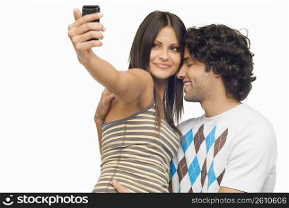Close-up of a young couple taking a photograph of themselves with a mobile phone
