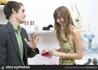 Close-up of a young couple talking to each other in a clothing store