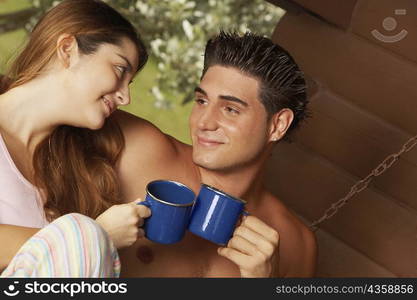 Close-up of a young couple toasting cups of tea