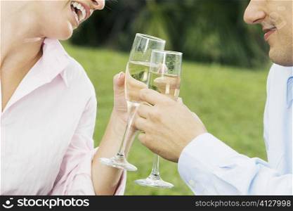Close-up of a young couple toasting with champagne flutes