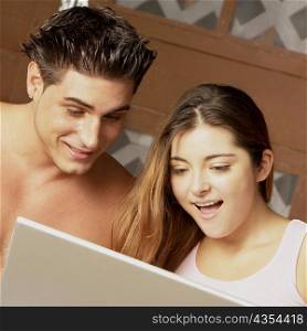 Close-up of a young couple using a laptop