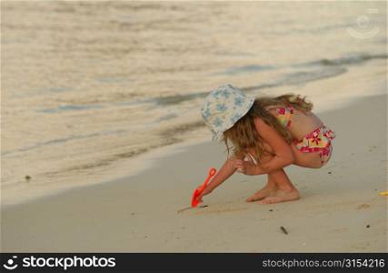 Close-up of a young girl (6-8) playing on a beach, Moorea, Tahiti, French Polynesia, South Pacific