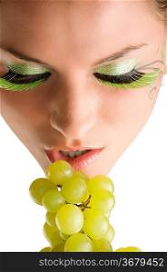 close up of a young girl and beautiful girl with grape near her mouth