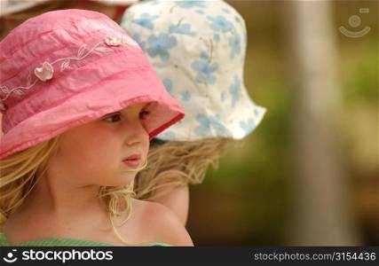 Close-up of a young girl wearing a pink sun hat, Moorea, Tahiti, French Polynesia, South Pacific