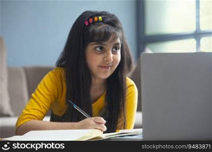 Close up of a young girl working in front of the laptop
