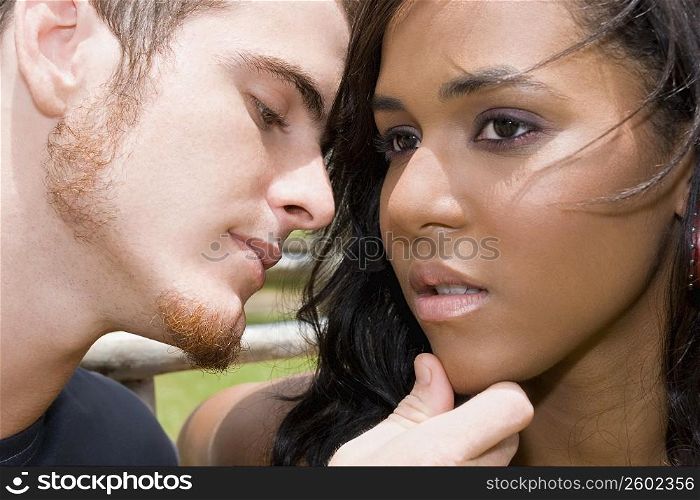 Close-up of a young man about to kiss a teenage girl