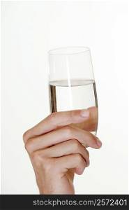 Close-up of a young man&acute;s hand holding a glass of water