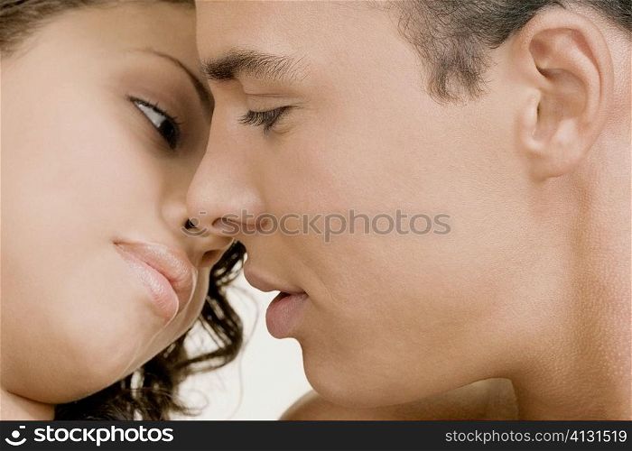 Close-up of a young man and a teenage girl facing each other