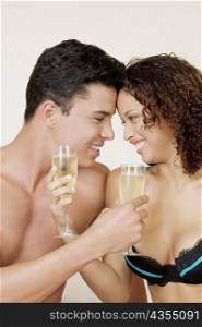 Close-up of a young man and a teenage girl holding champagne flutes